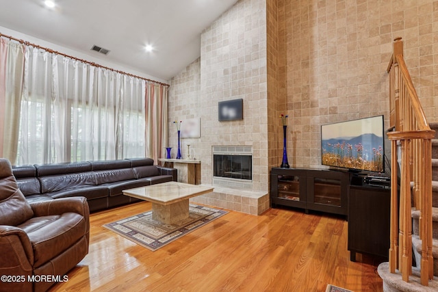 149 Jefferson Dr, Ocean Twp, NJ 07712 - living room featuring wood finished floors, a tiled fireplace, high vaulted ceiling, and recessed lighting