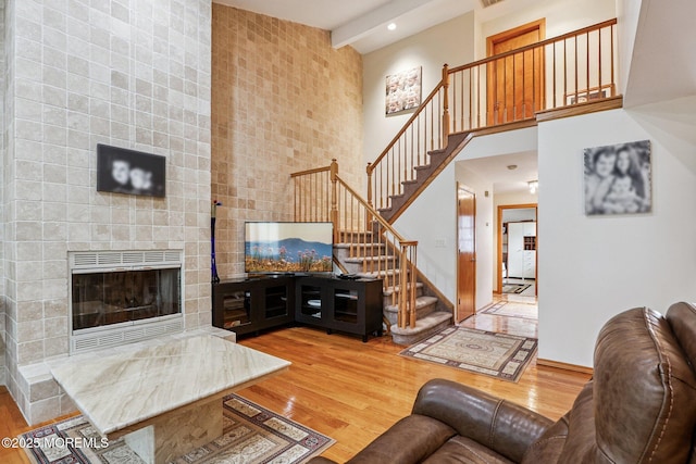 149 Jefferson Dr, Ocean Twp, NJ 07712 - living room featuring wood finished floors, stairway, a high ceiling, a fireplace, and heating unit