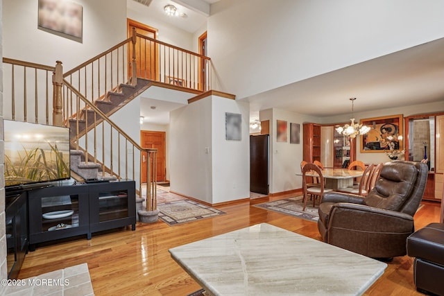 149 Jefferson Dr, Ocean Twp, NJ 07712 - living room featuring a chandelier, wood finished floors, stairs, and a towering ceiling