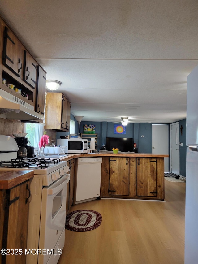 1881 Rte 37 Unit 347, Toms River, NJ 08757 - kitchen featuring white appliances, light wood-type flooring, range hood, a peninsula, and brown cabinetry