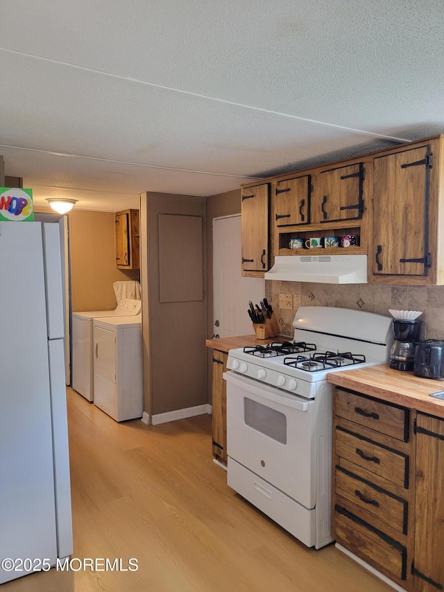 1881 Rte 37 Unit 347, Toms River, NJ 08757 - kitchen featuring white appliances, under cabinet range hood, washer and dryer, and brown cabinets