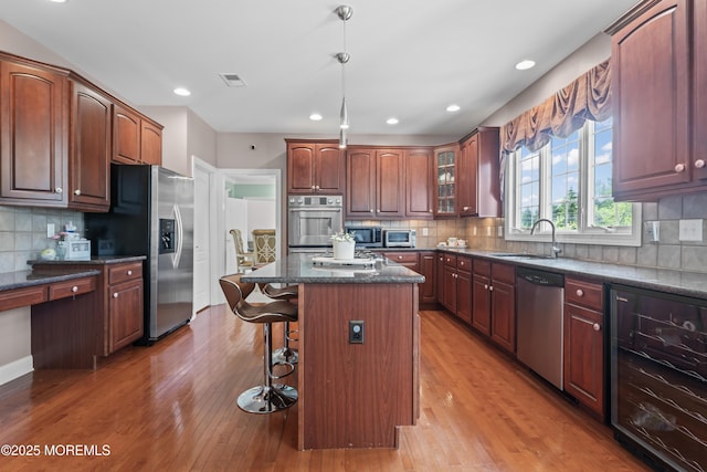 1 Hopkinson Ct, Marlboro, NJ 07746 - kitchen featuring stainless steel appliances, beverage cooler, a breakfast bar area, tasteful backsplash, and a center island