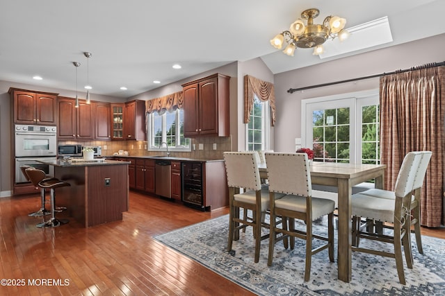 1 Hopkinson Ct, Marlboro, NJ 07746 - kitchen with wine cooler, stainless steel appliances, a center island, a kitchen breakfast bar, and a chandelier