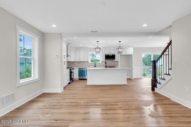 629 Monmouth Ave, Toms River, NJ 08757 - kitchen featuring white cabinetry, light wood-type flooring, tasteful backsplash, recessed lighting, and stainless steel gas range