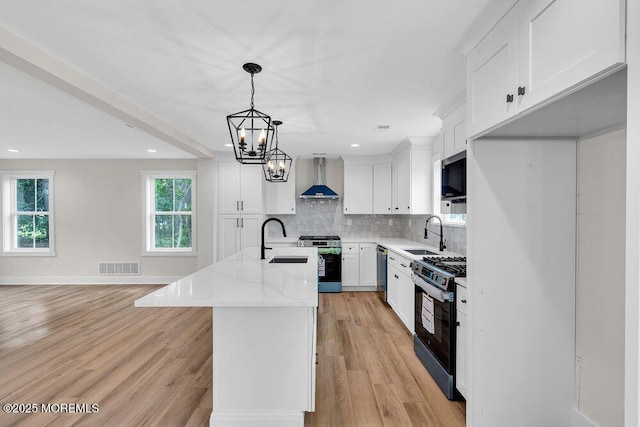 629 Monmouth Ave, Toms River, NJ 08757 - kitchen with appliances with stainless steel finishes, wall chimney range hood, backsplash, recessed lighting, and white cabinetry