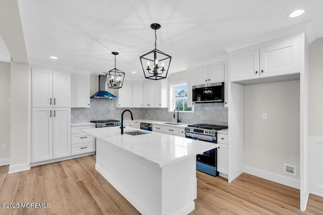 629 Monmouth Ave, Toms River, NJ 08757 - kitchen with stainless steel appliances, wall chimney range hood, a chandelier, white cabinets, and recessed lighting