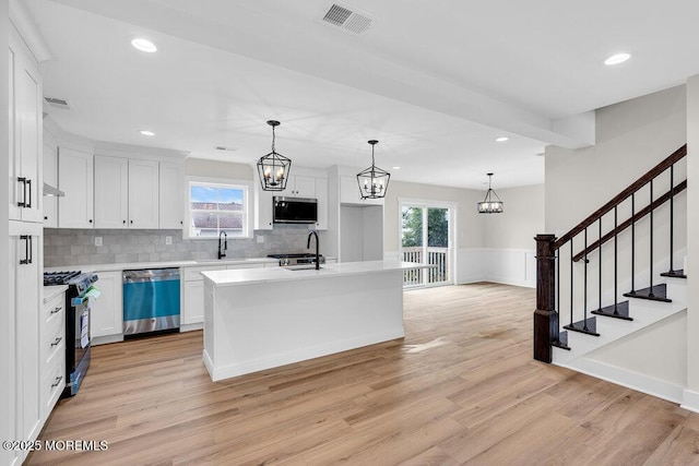 629 Monmouth Ave, Toms River, NJ 08757 - kitchen featuring stainless steel appliances, light wood-type flooring, a chandelier, light countertops, and wainscoting