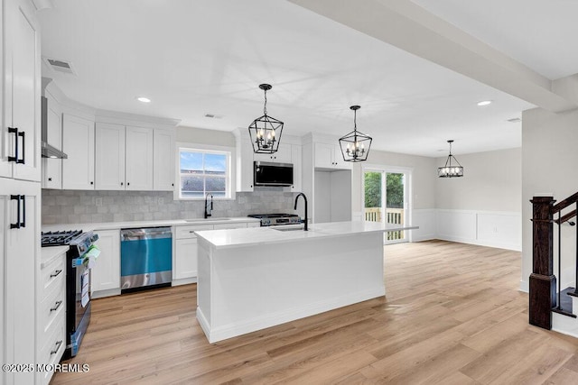 629 Monmouth Ave, Toms River, NJ 08757 - kitchen featuring appliances with stainless steel finishes, a chandelier, light countertops, wainscoting, and white cabinets