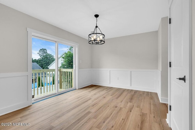 629 Monmouth Ave, Toms River, NJ 08757 - empty room featuring a chandelier, light wood-style flooring, and wainscoting