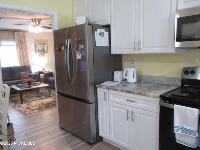 496A Thornbury Ct, Lakewood, NJ 08701 - kitchen with appliances with stainless steel finishes, light wood-style floors, white cabinets, and a ceiling fan