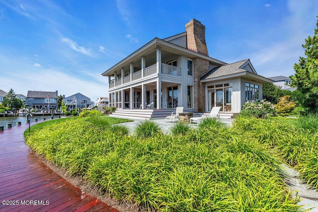 787 Princeton Ave, Brick, NJ 08724 - back of property with a balcony, a chimney, board and batten siding, and a water view
