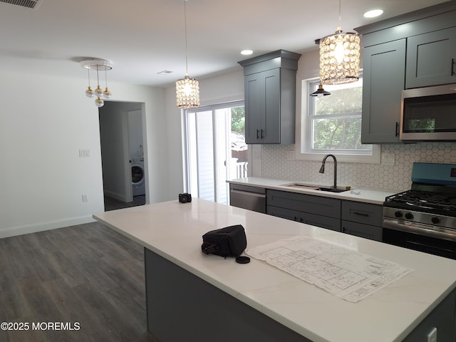 414 Oak Tree Rd, Freehold, NJ 07728 - kitchen with stainless steel appliances, washer / dryer, a chandelier, backsplash, and dark wood-style floors