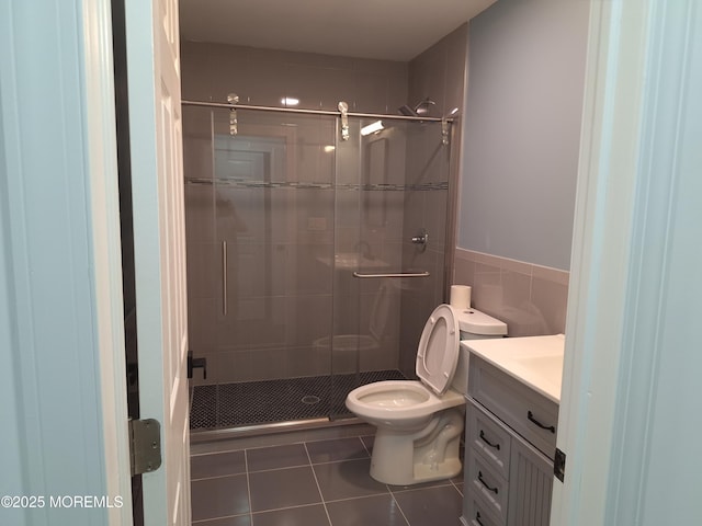 414 Oak Tree Rd, Freehold, NJ 07728 - full bathroom featuring vanity, a shower stall, tile patterned floors, tile walls, and wainscoting