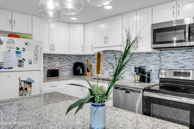 2108 SE Central Ave Unit 10, South Seaside Park, NJ 08752 - kitchen with stainless steel appliances, white cabinetry, light stone counters, decorative backsplash, and recessed lighting