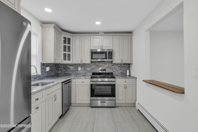 925 Edgebrook Dr N, Toms River, NJ 08757 - kitchen featuring appliances with stainless steel finishes, a baseboard heating unit, light stone counters, decorative backsplash, and glass insert cabinets