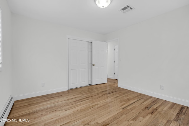 925 Edgebrook Dr N, Toms River, NJ 08757 - unfurnished bedroom with a baseboard heating unit, light wood-style flooring, and a closet