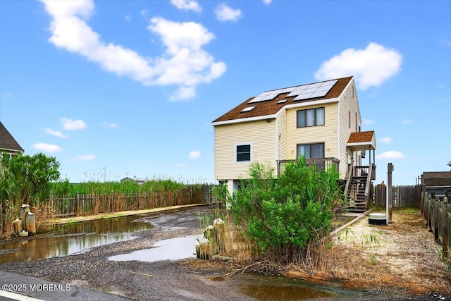 322 Dock Rd, West Creek, NJ 08092 - view of front facade featuring solar panels, stairway, and a wooden deck