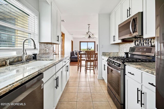 322 Dock Rd, West Creek, NJ 08092 - kitchen with appliances with stainless steel finishes, decorative backsplash, white cabinetry, and light tile patterned floors