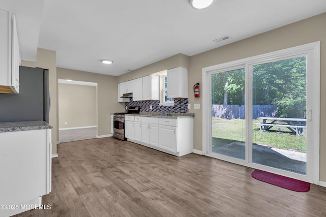 971 Center St, Little Egg Harbor, NJ 08087 - kitchen featuring stainless steel appliances, white cabinets, under cabinet range hood, backsplash, and light wood-type flooring
