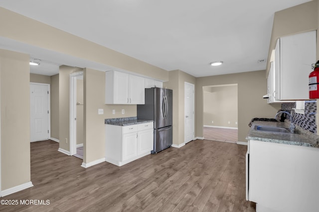 971 Center St, Little Egg Harbor, NJ 08087 - kitchen featuring freestanding refrigerator, light wood-style floors, white cabinets, decorative backsplash, and stone countertops