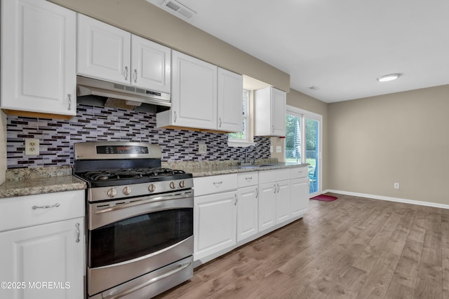 971 Center St, Little Egg Harbor, NJ 08087 - kitchen featuring stainless steel gas stove, under cabinet range hood, decorative backsplash, and white cabinetry