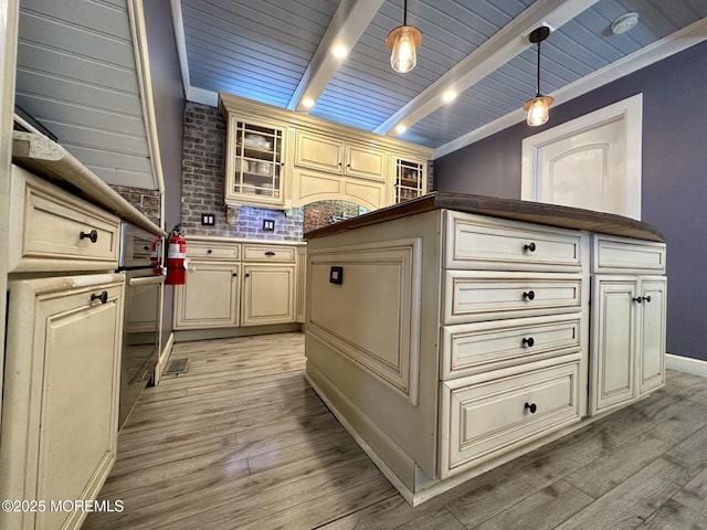 224 5th St Unit A, Beach Haven, NJ 08008 - kitchen with cream cabinetry, light wood-type flooring, hanging light fixtures, glass insert cabinets, and backsplash