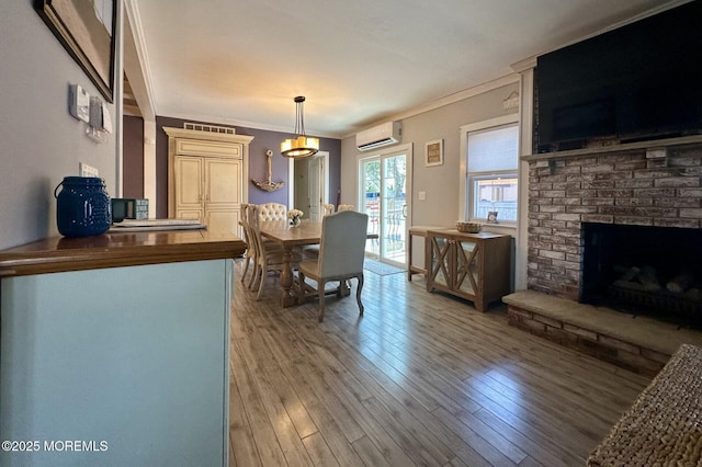 224 5th St Unit A, Beach Haven, NJ 08008 - dining area featuring a wall mounted AC, ornamental molding, a brick fireplace, and light wood-type flooring