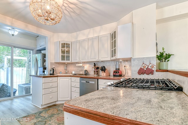 132 Heck Ave, Ocean Grove, NJ 07756 - kitchen with stainless steel appliances, white cabinetry, light wood-style flooring, and tasteful backsplash