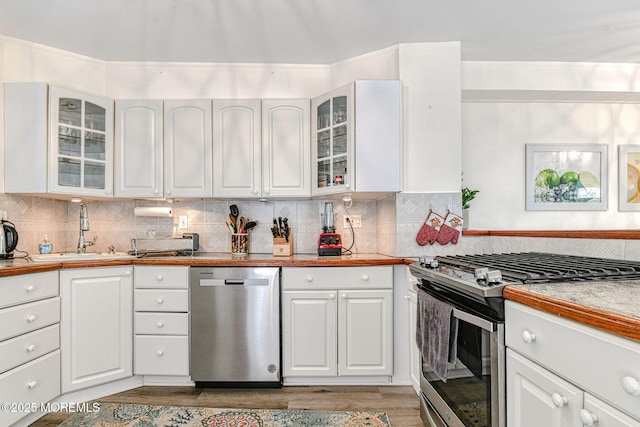 132 Heck Ave, Ocean Grove, NJ 07756 - kitchen with appliances with stainless steel finishes, white cabinets, light wood-style flooring, tasteful backsplash, and light countertops