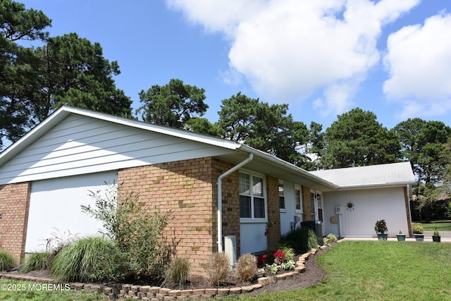8B Cambridge Cir, Manchester, NJ 08759 - view of side of home featuring a lawn, brick siding, and a garage