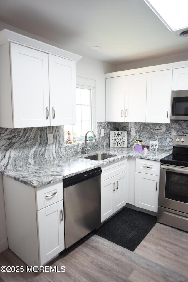 8B Cambridge Cir, Manchester, NJ 08759 - kitchen featuring appliances with stainless steel finishes, dark wood-style floors, decorative backsplash, and white cabinetry
