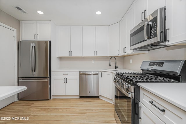 701 Zlotkin Cir Unit 1, Freehold, NJ 07728 - kitchen with appliances with stainless steel finishes, white cabinets, recessed lighting, light countertops, and light wood-style floors