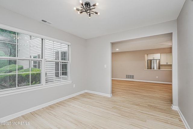 701 Zlotkin Cir Unit 1, Freehold, NJ 07728 - empty room with a chandelier, healthy amount of natural light, and light wood-type flooring