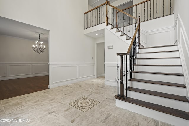 29 Lorton Rd, Old Bridge, NJ 08857 - stairs with a decorative wall, a chandelier, a towering ceiling, wainscoting, and crown molding