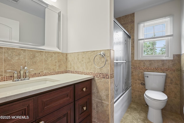 29 Lorton Rd, Old Bridge, NJ 08857 - full bathroom featuring tile walls, vanity, bath / shower combo with glass door, tile patterned flooring, and a wainscoted wall