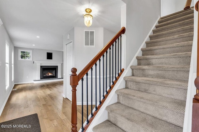 1207 Bayberry Rd, Manasquan, NJ 08736 - stairway with wood finished floors, recessed lighting, and a warm lit fireplace