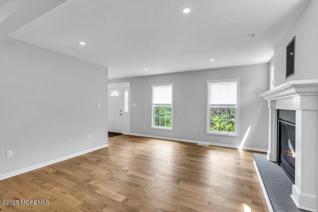 1207 Bayberry Rd, Manasquan, NJ 08736 - unfurnished living room featuring a glass covered fireplace, wood finished floors, and recessed lighting