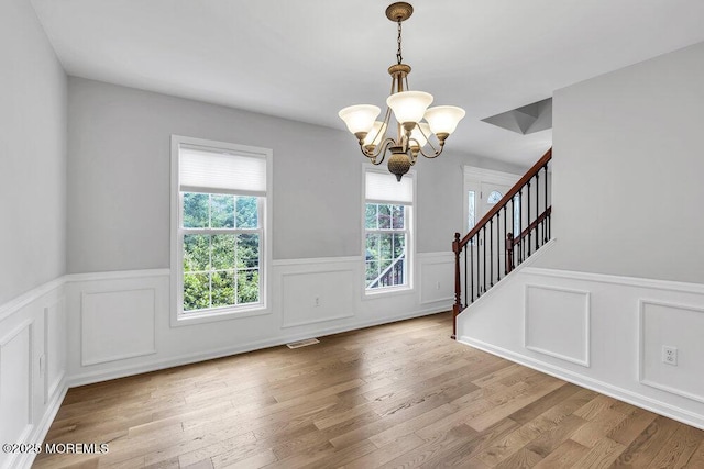 1207 Bayberry Rd, Manasquan, NJ 08736 - entryway featuring a chandelier, wainscoting, a decorative wall, wood finished floors, and stairs
