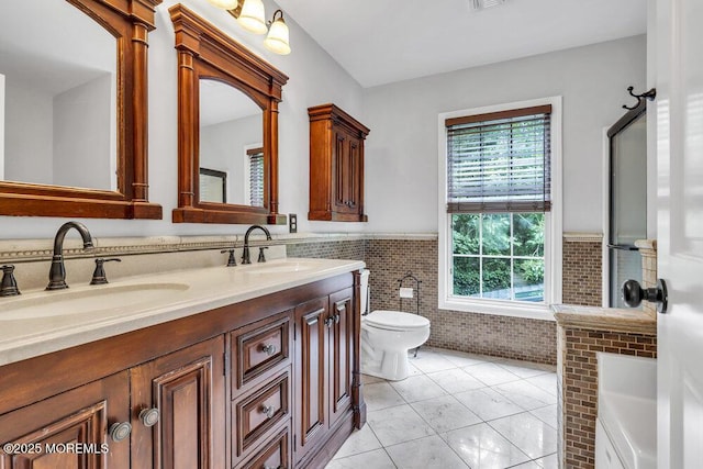 1207 Bayberry Rd, Manasquan, NJ 08736 - bathroom with double vanity, tile walls, wainscoting, tile patterned floors, and a tub to relax in