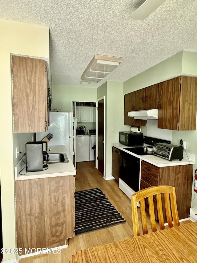 7 S Seas Ct, Barnegat, NJ 08005 - kitchen with electric range, ventilation hood, black microwave, light wood-style floors, and washer and dryer