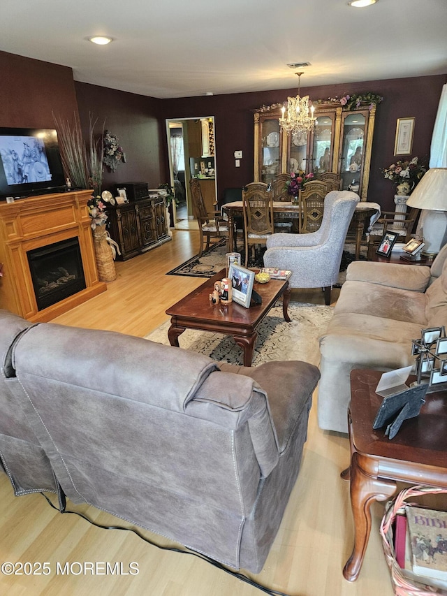 24 Christiansted St, Toms River, NJ 08757 - living room with wood finished floors, a chandelier, a fireplace, and recessed lighting