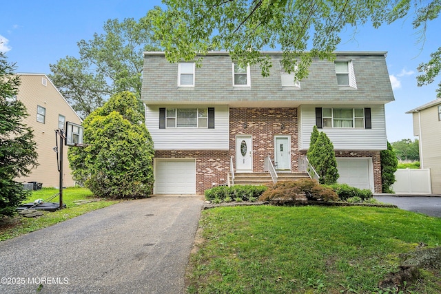 28 Dortmunder Dr, Manalapan, NJ 07726 - raised ranch with an attached garage, brick siding, asphalt driveway, mansard roof, and a shingled roof