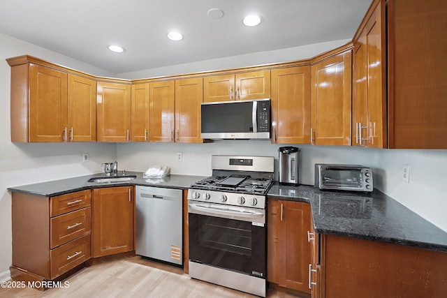28 Dortmunder Dr, Manalapan, NJ 07726 - kitchen with appliances with stainless steel finishes, brown cabinets, light wood-type flooring, dark stone countertops, and recessed lighting