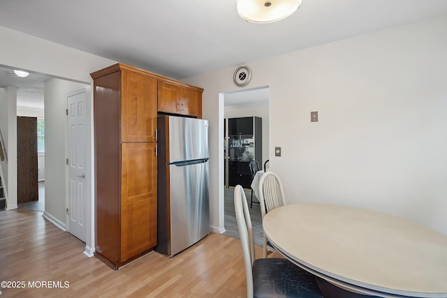 28 Dortmunder Dr, Manalapan, NJ 07726 - kitchen featuring freestanding refrigerator, light wood-style floors, and brown cabinetry