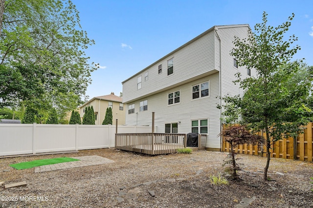 28 Dortmunder Dr, Manalapan, NJ 07726 - rear view of house with a wooden deck and a fenced backyard