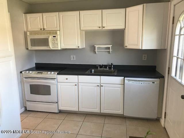 101 Village Green Way, Hazlet, NJ 07730 - kitchen featuring white appliances, dark countertops, white cabinets, and light tile patterned floors