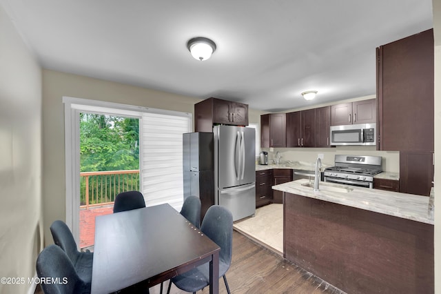 23 Montana Dr, Jackson, NJ 08527 - kitchen with dark brown cabinets, appliances with stainless steel finishes, light stone counters, wood finished floors, and a peninsula