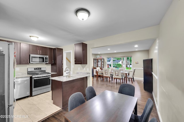 23 Montana Dr, Jackson, NJ 08527 - kitchen featuring stainless steel appliances, dark brown cabinets, a peninsula, light wood-style floors, and light stone countertops