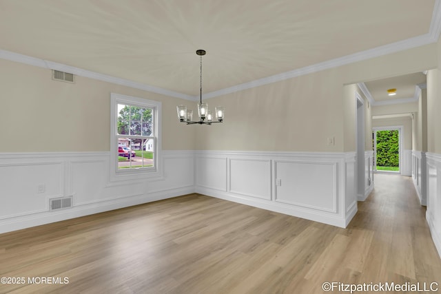 13 Everest Dr N, Brick, NJ 08724 - unfurnished dining area featuring plenty of natural light, a chandelier, wainscoting, light wood finished floors, and crown molding