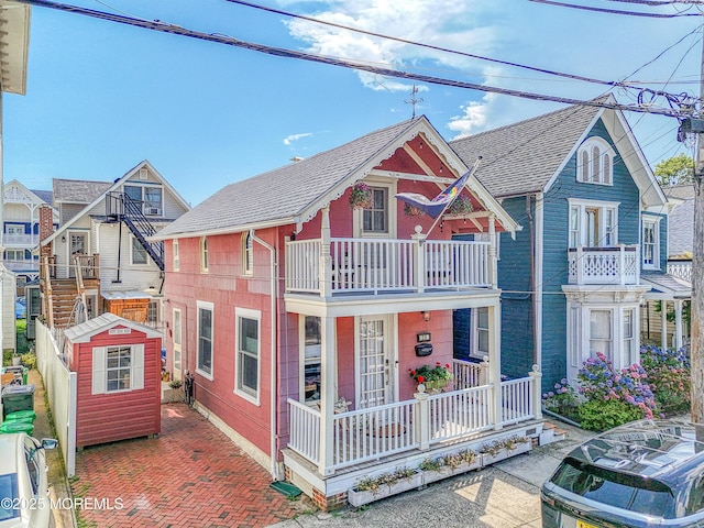 28 Olin St, Ocean Grove, NJ 07756 - view of front facade featuring covered porch, roof with shingles, a balcony, and a storage unit